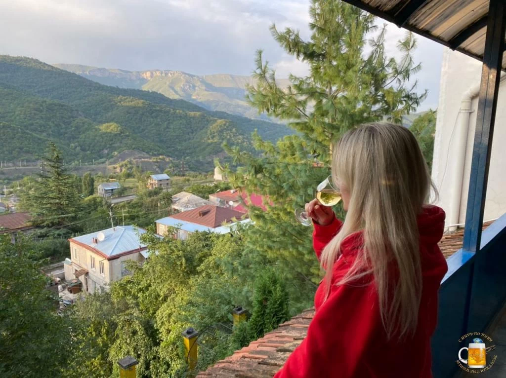 Жена с армянским вином на фоне армянских гор в Дилижане